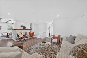 Living area featuring wood finished floors, a premium fireplace, recessed lighting, and beamed ceiling