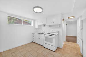 Kitchen with white appliances, white cabinetry, light countertops, and light tile patterned floors
