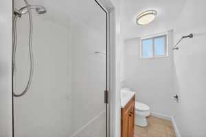 Full bath featuring vanity, a stall shower, and light tile patterned floors