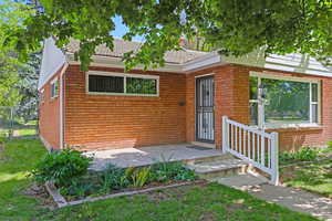 View of front of property with brick siding and a gate