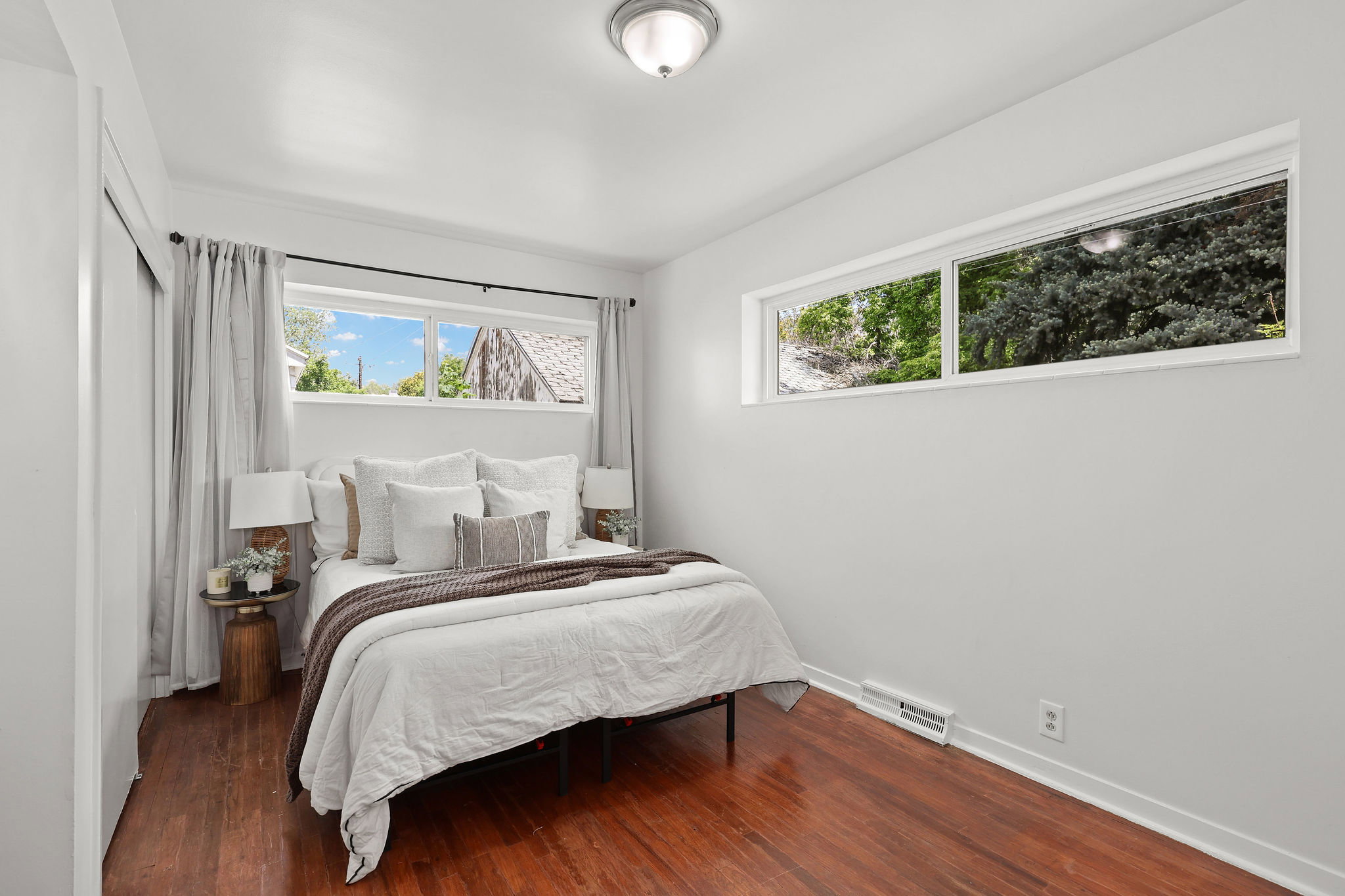 Hardwood flooring throughout, white walls, and a contemporary ceiling light fixture