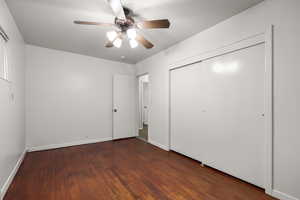 Unfurnished bedroom featuring dark wood-style floors, ceiling fan, and a closet