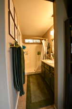Full bath with vanity, a shower stall, and dark tile patterned flooring