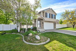 View of front of house featuring driveway, a garage, brick siding, and a gate