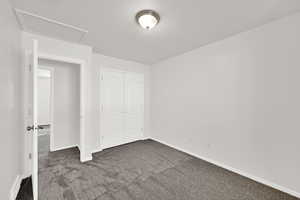 Unfurnished bedroom featuring dark colored carpet and a closet