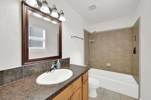 Bathroom featuring vanity, tub / shower combination, and light tile patterned floors