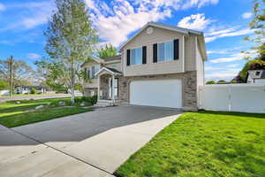 View of front of home with driveway, a garage, a gate, and brick siding