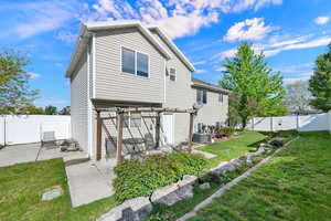 Rear view of house featuring a fenced backyard and a patio area