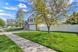 View of front of home with an attached garage, concrete driveway, brick siding, and a residential view