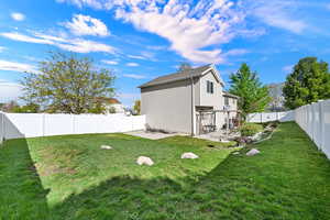 Back of house with a patio area, a fenced backyard, and a gate