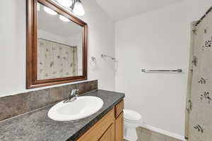 Full bathroom with vanity, a shower with shower curtain, and light tile patterned flooring