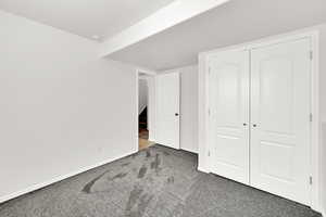 Unfurnished bedroom featuring carpet floors and a closet