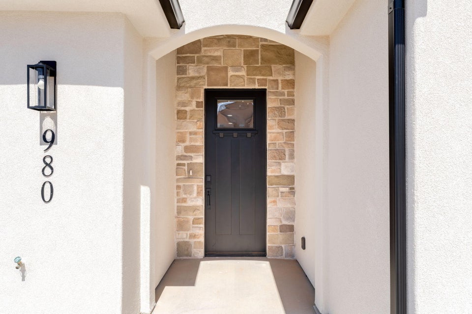 Property entrance with stone siding and stucco siding