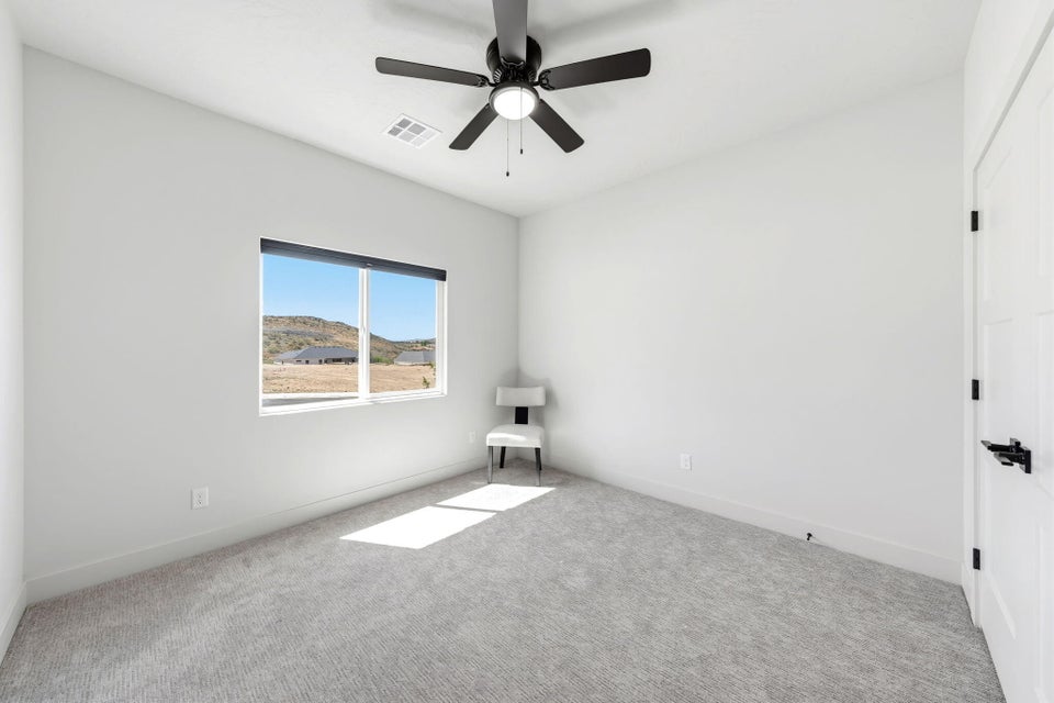 Unfurnished room featuring carpet flooring and ceiling fan