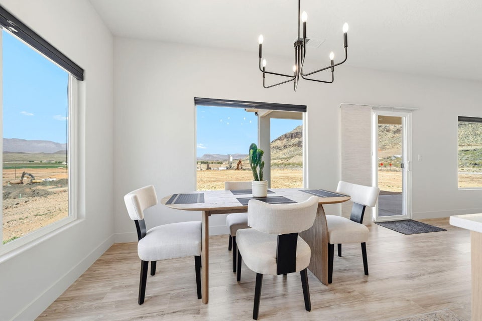 Dining area with a mountain view, light wood-style floors, and suspended lighting