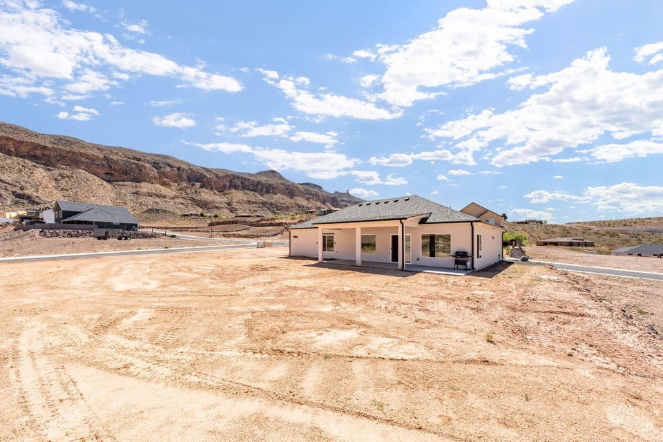 View of front of property featuring a mountain view, a patio, and stucco siding