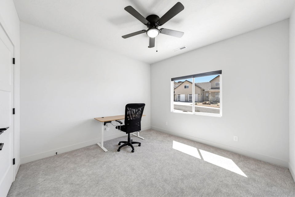 Unfurnished office featuring light carpet and ceiling fan