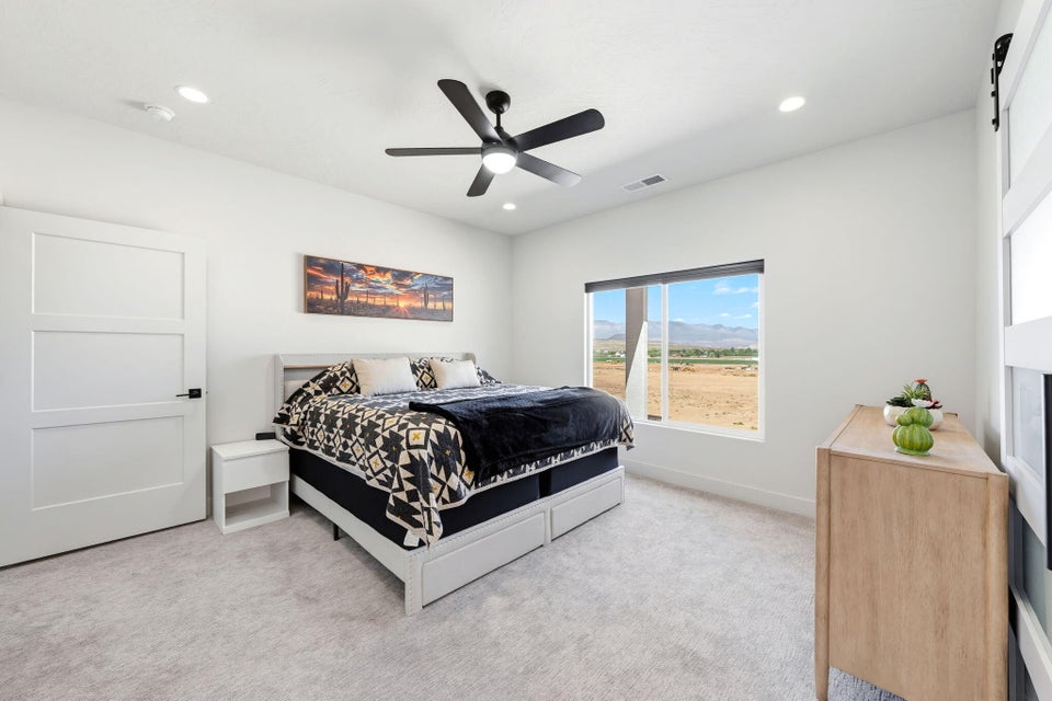 Bedroom with a barn door, a mountain view, light carpet, a ceiling fan, and recessed lighting