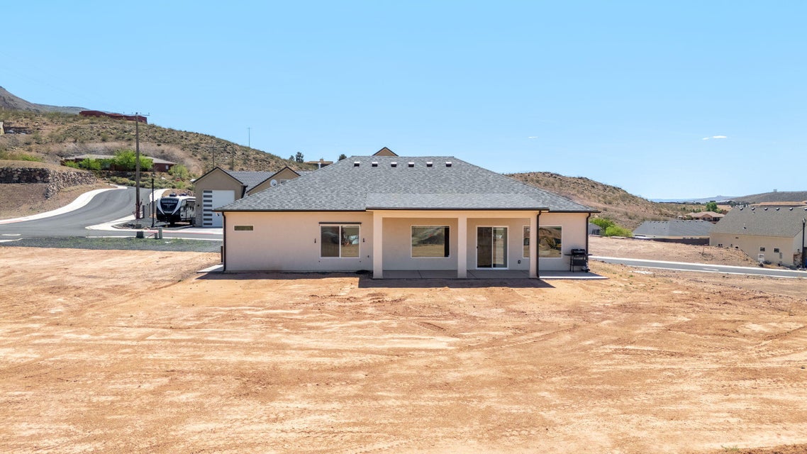 Back of house featuring a mountain view, a patio area, and stucco siding