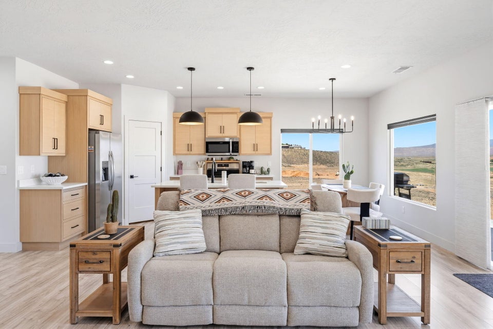 Living room with light wood finished floors and hanging lights