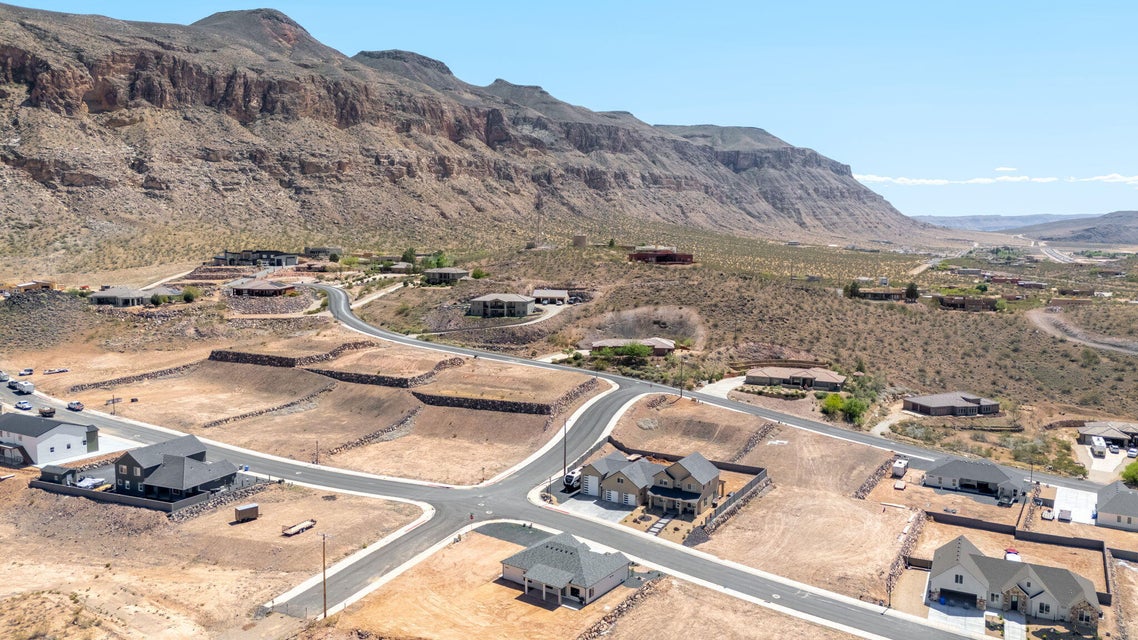 Aerial view of property and surrounding area with mountains and nearby suburban area