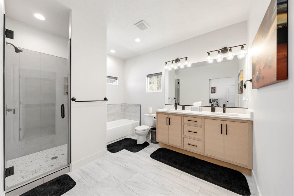Bathroom featuring double vanity, a stall shower, a bath, and recessed lighting