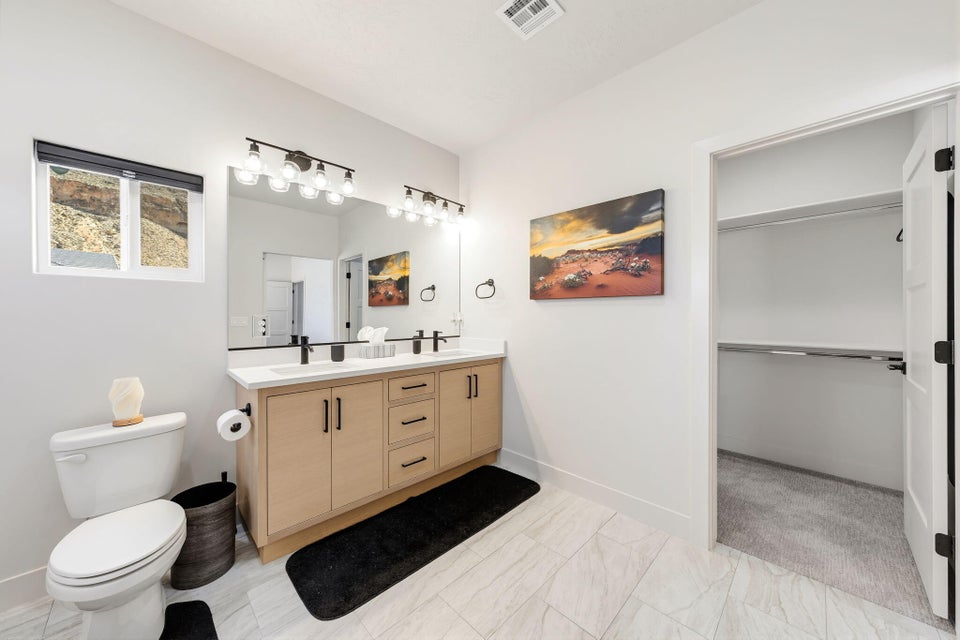 Bathroom with double vanity and a walk in closet