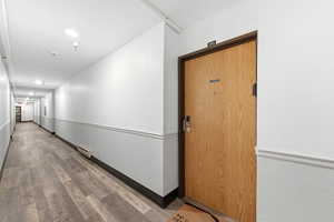 Hallway featuring light wood finished floors and baseboards