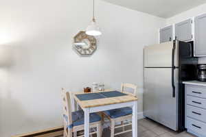 Dining area featuring a baseboard heating unit and light tile patterned flooring
