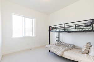 Bedroom featuring light colored carpet and baseboards