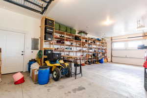 Garage featuring electric panel and a garage door opener