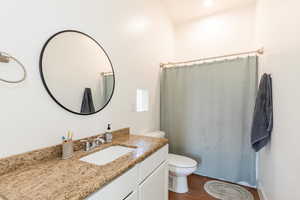 Full bathroom featuring vanity, curtained shower, and dark tile patterned floors