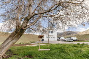 View of front facade featuring a garage, gravel driveway, and a mountain view