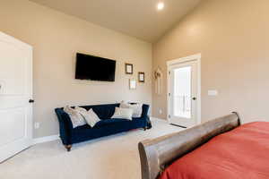 Bedroom with carpet floors, vaulted ceiling, and access to exterior