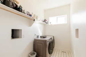 Laundry area featuring washing machine and dryer and light tile patterned floors