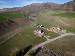 Aerial view of sparsely populated area featuring property boundaries highlighted and a mountain backdrop