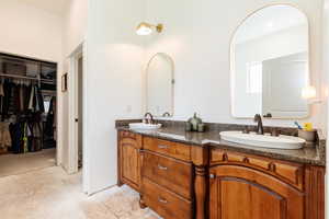 Bathroom featuring double vanity and a spacious closet