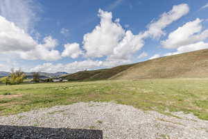 View of green lawn featuring a mountain view and a view of rural / pastoral area