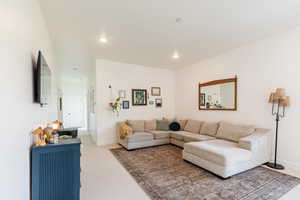 Living room with light colored carpet and recessed lighting
