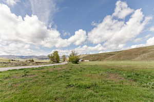View of green lawn with a view of rural / pastoral area and a mountain view