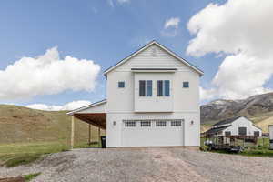 View of front of house with a mountain view, driveway, and a garage