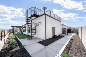 View of property exterior with a fenced backyard, stucco siding, a putting green, and a patio