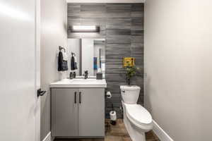 Bathroom with tile walls, vanity, and an accent wall