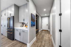 Hallway with light wood-style floors and recessed lighting