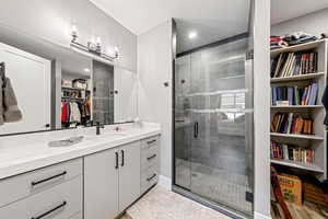 Bathroom featuring a spacious closet, vanity, a stall shower, and recessed lighting