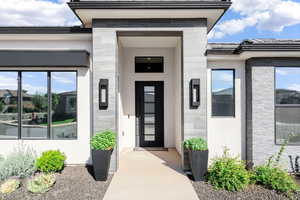 Entrance to property featuring stone siding, stucco siding, and a tiled roof