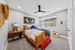 Bedroom with ceiling fan and light carpet