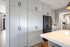 Kitchen featuring high quality fridge, recessed lighting, light wood-type flooring, and gray cabinetry