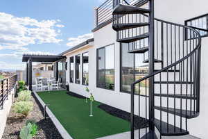 View of property exterior featuring a patio area, a fenced backyard, stucco siding, and an area to practice putting