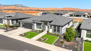View of front of home with a front yard, a garage, concrete driveway, a residential view, and a mountain view